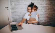 mum holding kid on laptop