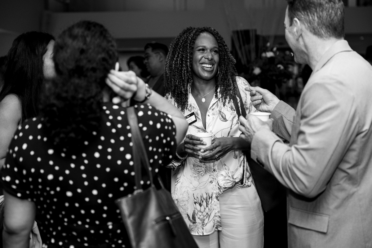 A group of individuals happily interacting and networking with one another.