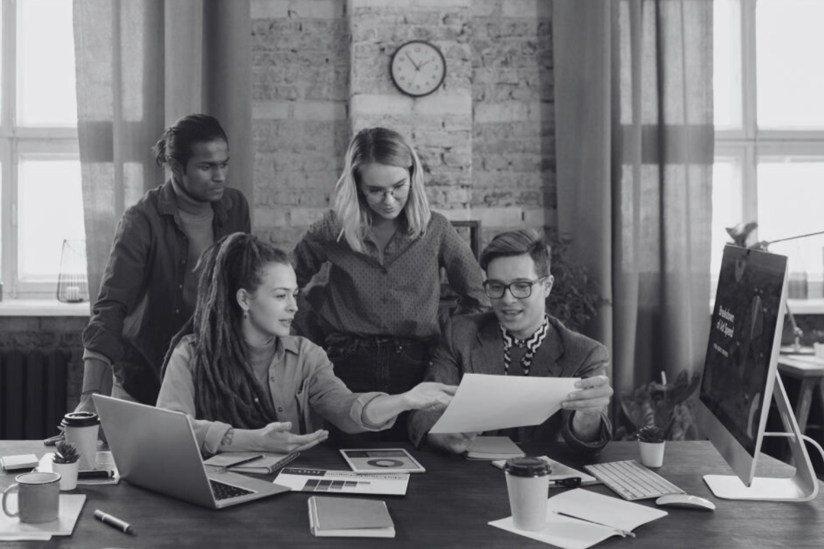 group of people standing together looking at marketing work