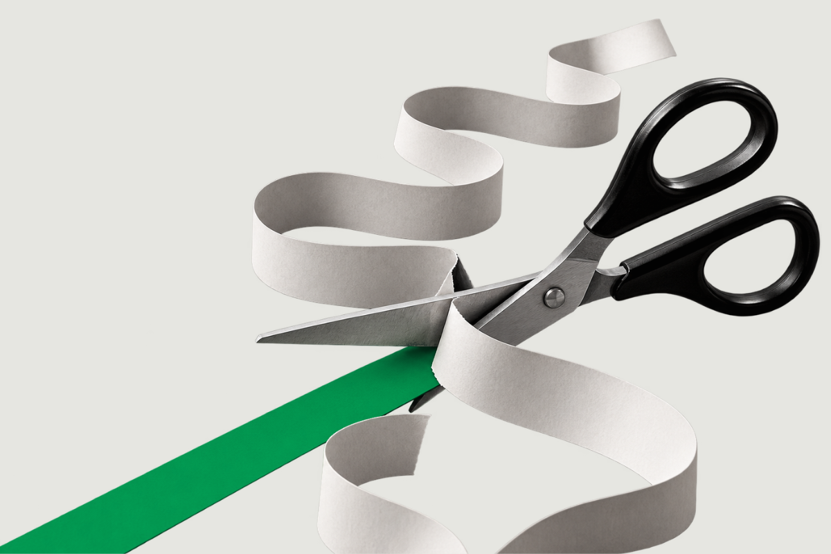 A pair of scissors cuts through a winding strip of white paper to reveal a clear green path